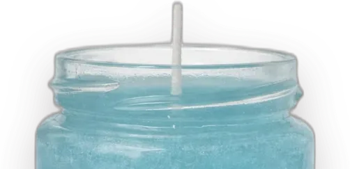A gel candle in a glass jar: sea-blue gel over a clear layer with white flowers and shells, on white sand